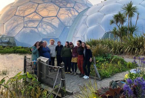 A women's leadership retreat group smiling in front of the Biomes